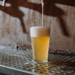 Craft Beer Bars - Beer Pouring Into Clear Drinking Glass on Metal Surface
