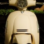 Urban Parks - A white moped parked on a sidewalk next to a building