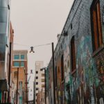 Street Murals - Empty Street Between Brown Concrete Buildings
